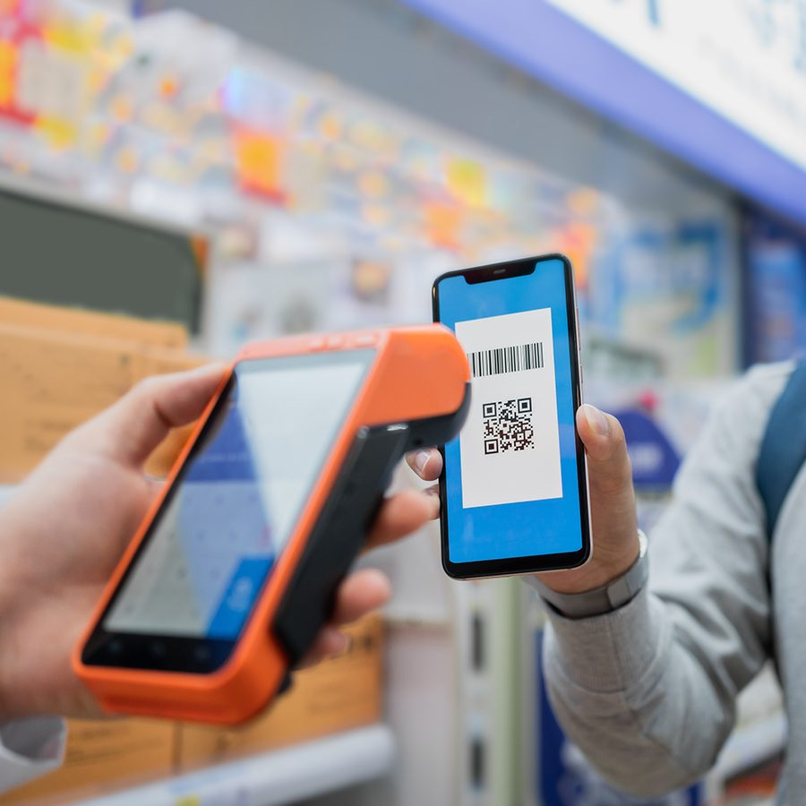 Alipay scan to pay scene showing a phone scanning a merchant QR code